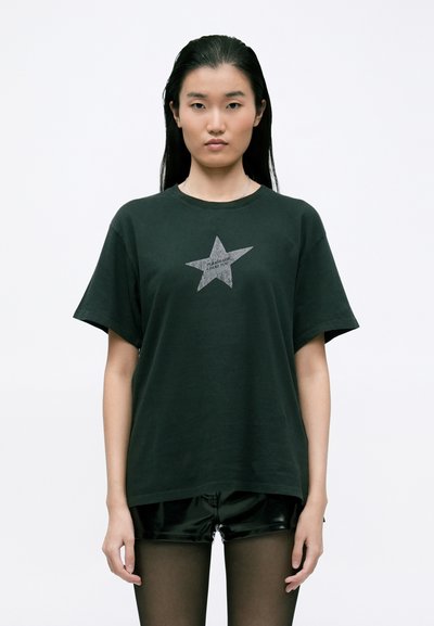 T-shirt en coton noir avec un grand graphique d'étoile grise au centre, disposant de manches courtes et d'une coupe ample.