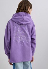 Fioletowa bluza z kapturem z wzorem czaszki i piszczeli wykonanym z cekinów na plecach. Materiał bawełniany, luźny krój, przestronny kaptur.