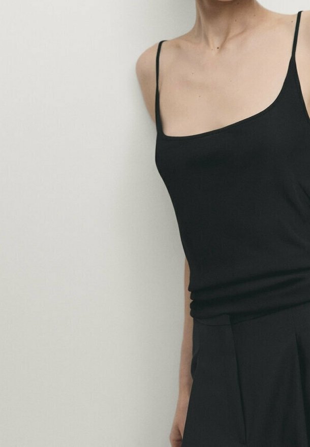 Top camisolé noir sans manches avec un décolleté droit et des fines bretelles, fabriqué en tissu lisse et extensible ; silhouette ajustée.