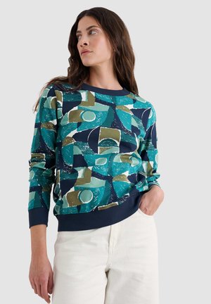 Multifarbener Sweatshirt mit geometrischen Mustern in Taubenblau, Marineblau und Olivgrün, mit einem einfarbigen Marineblauen Rippkragen und Rippbündchen.