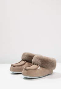 Brown suede slippers with a fluffy fleece cuff, rounded toe design, and a soft gray sole, featuring minimal hardware and no visible patterns.