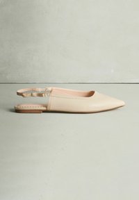 Chaussure plate slingback beige clair avec un bout pointu, dessus en cuir lisse, et une fine bride élastique au talon. Semelle plate en caoutchouc.