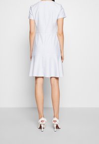 Lichtblauw uitlopend jurkje met korte mouwen, een gladde textuur en een gedefinieerde taille, voorzien van een rits aan de achterkant en een subtiele flounce zoom.