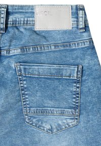 Poche arrière d'un jean en denim bleu clair avec double surpiqûre et une étiquette argentée portant l'inscription « WHEREVER YOU GO CECIL ».