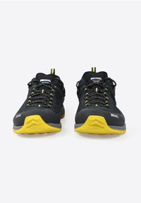 Scarpe da trekking nere con dettagli gialli, tomaia texture, lacci robusti e suola resistente. Progettate per l'uso all'aperto.