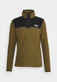 Sudadera de forro polar verde oliva con una sección superior negra, cuello alto y cuatro botones a presión. Cuenta con bolsillos laterales y un logo en el pecho.