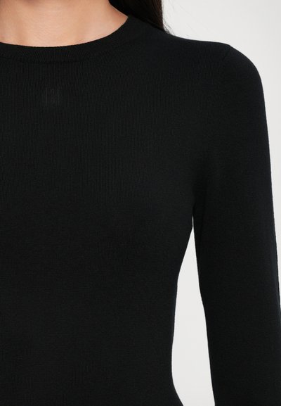 Black long-sleeve top with a ribbed texture and a round neckline. Features subtle branding near the collar, made from a soft knit material.