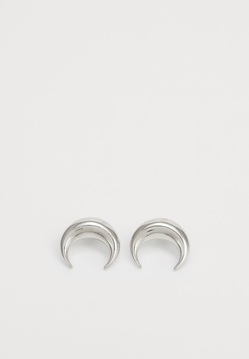 Boucles d'oreilles en métal argenté en forme de croissants de lune, présentant une surface lisse et brillante avec des bords arrondis et une finition polie.