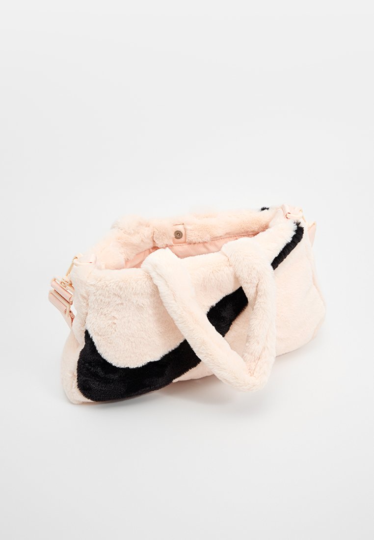 Borsa in pelliccia sintetica di colore rosa chiaro con un accento nero. Presenta un ampio interno e due manici spessi per un facile trasporto.