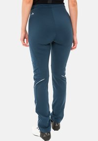 Marineblaue Sporthosen aus elastischem Material, mit seitlichen Akzenten und schmal zulaufendem Bein. Leicht und geeignet für sportliche Aktivitäten.