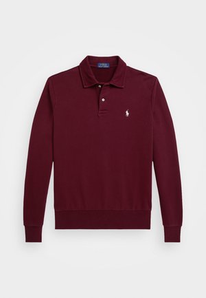 Long-sleeve burgundy polo shirt made of cotton. Features a classic collar, three-button placket, and embroidered logo on the chest. Smooth texture.