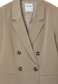 Beige Doppelreiher-Blazer mit Reverskragen, braunen Knöpfen und Seitentaschen. Strukturierter Stoff mit glattem Futter. Größe angegeben als S.