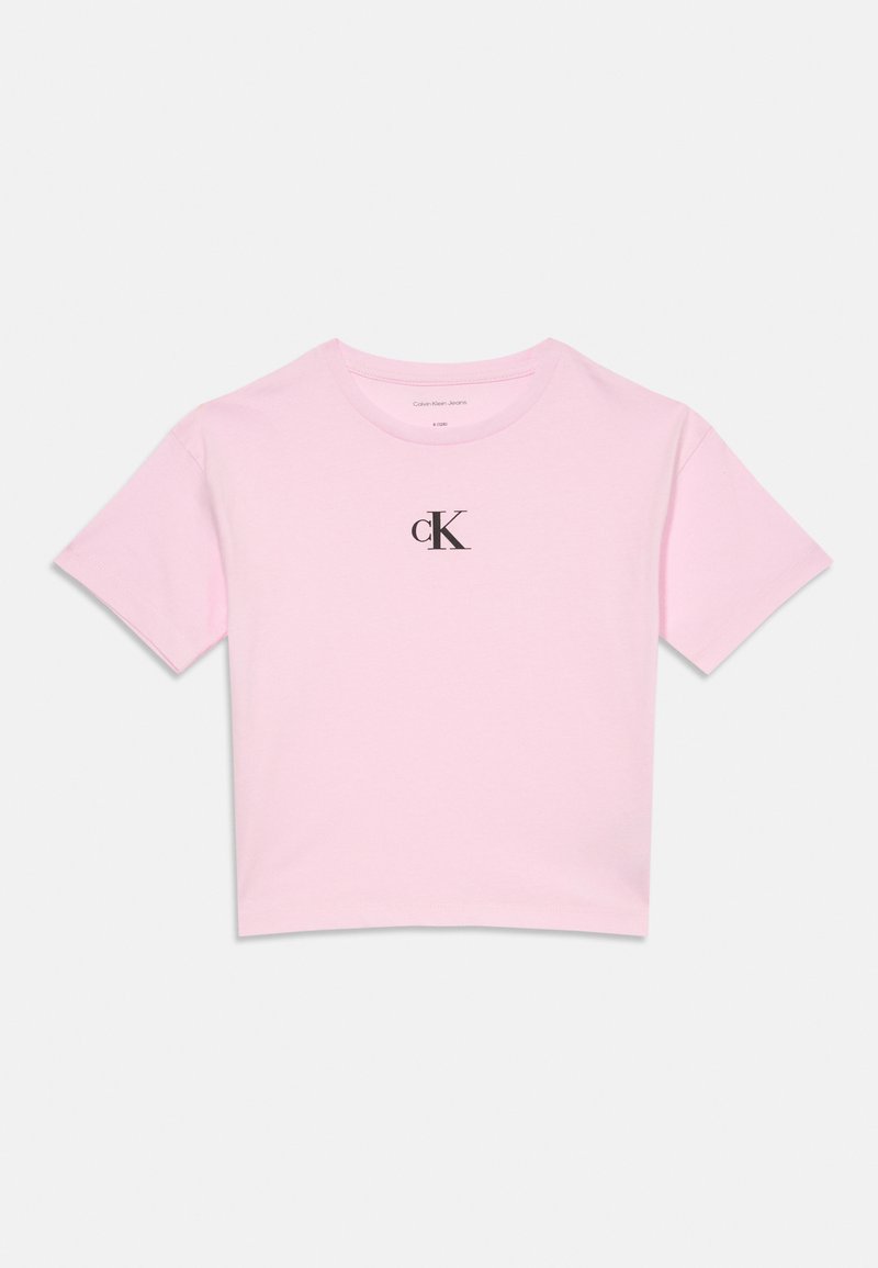 Šviesiai rožinė trumpomis rankovėmis, trumpa marškinėliai su juodu "cK" logotipu, atspausdintu krūtinės centre, ir apvaliu kaklu.