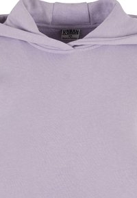 Felpa in cotone viola con colletto alto e una texture morbida. Etichetta visibile con "URBAN CLASSICS" e "Prodotto in Pakistan."