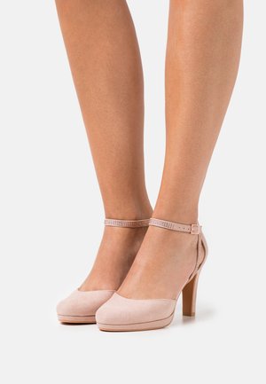 Helle rosa Wildleder-Pumps mit einer runden Zehenpartie, einem Knöchelriemen, der mit kleinen Strasssteinen verziert ist, und einem mittelhohen Stiletto-Absatz.