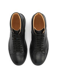 Černé kožené tenisky s vysokým svrškem mají hladkou texturu, kulatou špičku a šněrovací systém s béžovým vnitřkem a nenápadným značením.