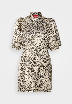 Haljina s životinjskim uzorkom u bež boji s crnim leopardskim točkama; ima napuhane rukave, visok ovratnik i prilagođeni kroj s kopčanjem na gumbe.