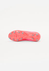 Pink soccer cleat sole features studs in a light blue accent, smooth textured surface, and a streamlined shape for traction and performance.
