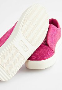 Zapatillas fucsias con un acabado texturizado y detalles de purpurina incrustados, con una suela de goma blanca y marca en relieve en la suela.