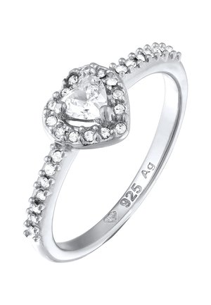 Bague en argent avec une pierre claire en forme de cœur, entourée de petites pierres claires sur une bande polie, marquée 925 pour argent sterling.