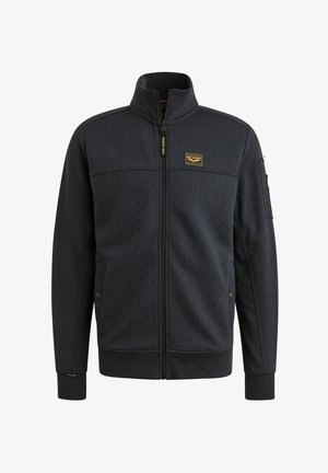 Tumma vetoketjullinen takki, jossa on hunajakenno-tekstuuri edessä, sileät hihat, vetoketjullinen tasku kädessä ja logo-patch rinnassa.