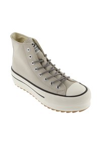 Sneaker alta beige con suola bianca spessa, striscia nera, occhielli argentati e lacci beige-neri a motivo su sfondo bianco.