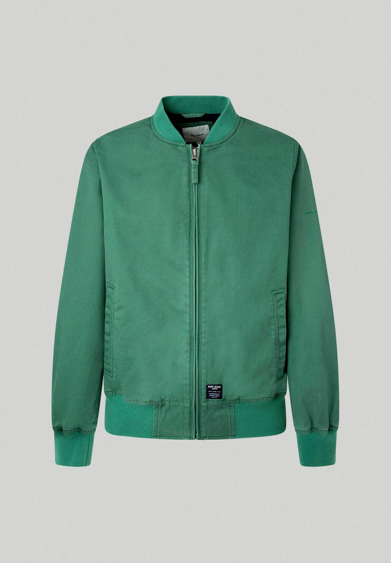 Chaqueta bomber verde de tejido suave, con cremallera frontal, puños y dobladillo acanalados, y bolsillos laterales. Etiqueta en la parte inferior izquierda.