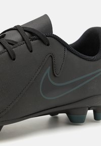 Schwarze Fußballschuhe mit einer glatten, matten Oberfläche, ausgestattet mit schwarzen Schnürsenkeln, einem niedrig geschnittenen Design und einem dunkelgrünen Nike-Swoosh-Logo an der Seite.