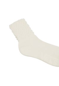 Weiße gestrickte Socke mit einem strukturierten, gerippten Bündchen und einem glatten Körper. Enthält dezente Logodetails an der Sohle. Aus weichem Baumwollgemisch.