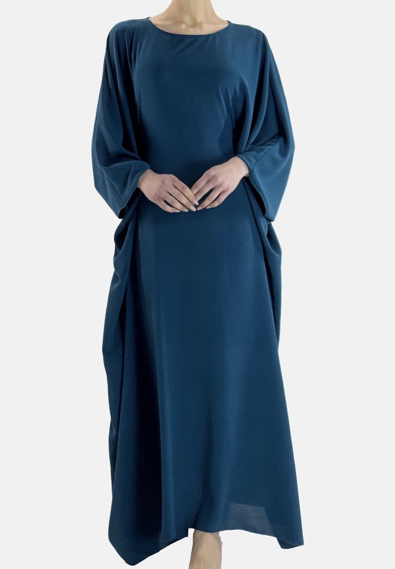 Abito lungo e ampio in tessuto verde petrolio intenso. Presenta maniche larghe, scollo rotondo e drappeggio laterale per aggiungere texture e forma.
