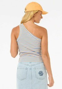 Gestreepte tanktop met een asymmetrisch ontwerp in oranje, blauw en crèmekleur; gecombineerd met een lichtblauwe spijkerrok met geborduurde details.