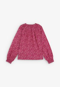 Blusa rosa con estampado floral, con escote plisado y mangas largas elásticas. La tela ligera crea una textura suave.