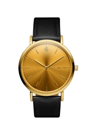 Gull rund urskive med minimalistiske timemarkører, svart skinnrem, merkenavn "SEIZMONT" på urskiven, viser klokkeslett 10:11:36.