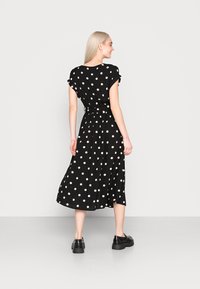 Schwarzes Polka-Dot-Midi-Kleid mit kurzen, umgeschlagenen Ärmeln und einem gebundenen Taillengürtel, aus leichtem Stoff gefertigt, mit einem fließenden Rock und dezentem Glanz.