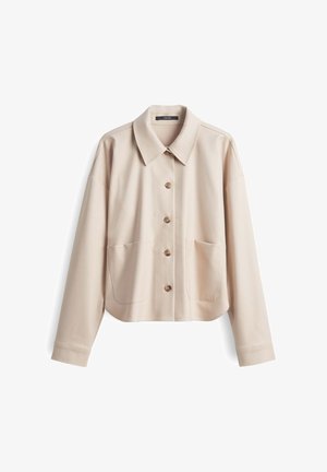 Giacca camicia cropped beige, realizzata in tessuto liscio, presenta un colletto a punta, chiusura con bottoni, due grandi tasche frontali e maniche lunghe.