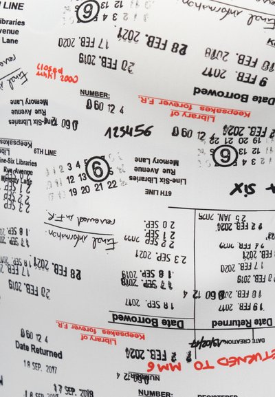 Biely textil potlačený rôznymi čiernymi a červenými údajmi z knižničného výpožičného lístka, vrátane dátumov, čísel a ručne písaných poznámok.