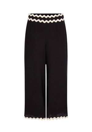 Pantalon large noir raccourci avec bordure blanche festonnée à la taille et à l'ourlet.