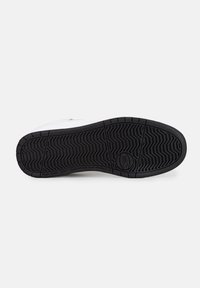 Sneaker bianca con suola in gomma nera texturizzata. Presenta un motivo a zigzag sulla suola. Accentuata con un branding sottile vicino al tallone.