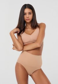Set beige in due pezzi composto da un reggiseno a V e da slip a vita alta, realizzato in tessuto morbido con design senza cuciture e senza hardware visibile.