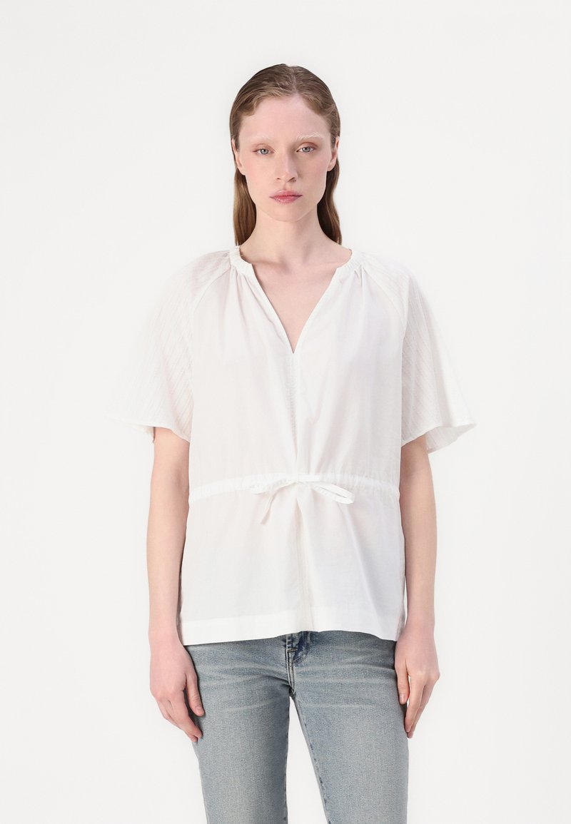 Weiße Bluse mit kurzen, leicht ausgestellten Ärmeln, gerafftem Ausschnitt und verstellbarem Taillenzug. Glattes Material mit dezenten Texturakzenten.