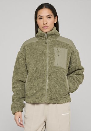 Olivengrøn fleecejakke med en tekstureret overflade, stående krave, lynlåslukning og en ensfarvet lysegrøn lomme på venstre bryst.