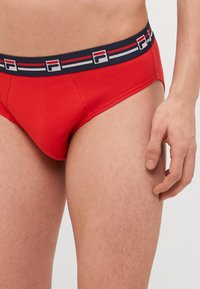 Boxer da uomo rossi in cotone, con un girovita elastico blu navy decorato con strisce rosse e bianche e dettaglio con logo.
