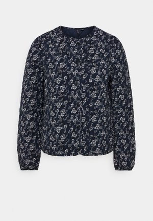 Marineblå quiltet jakke med hvidt blomstermønster over det hele, rund halsudskæring, lange ærmer og sort trykknaplukning foran.