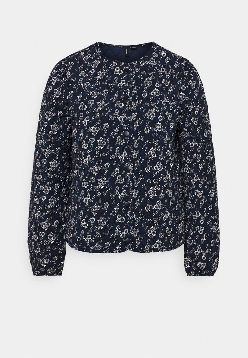 Veste matelassée bleu marine avec motif floral blanc intégral, col rond, manches longues, et fermeture à boutons-pression noirs sur le devant.