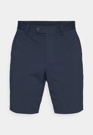 Calções azul-escuros com frente lisa, fecho de botão e passadores para cinto. Apresentam um tecido texturizado e corte direito, terminando acima do joelho.