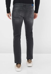 Jeans in denim grigio scuro con taglio dritto, dotati di due tasche posteriori e un'etichetta blu in vita. Tessuto liscio e sbiadimento minimo.