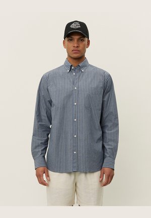 Gestreepte overhemden in blauwe en grijze tinten, katoen, lange mouwen, een borstzak, en standaard kraag. Gepaard met lichte shorts.