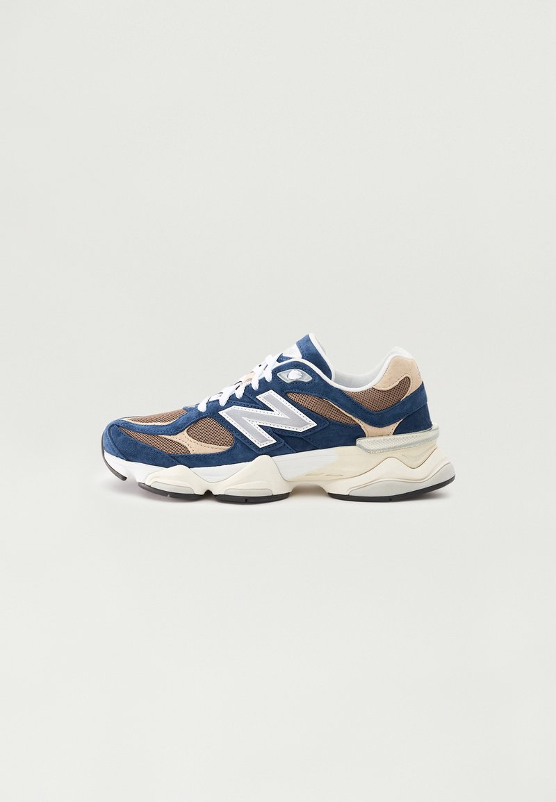 Navy and beige sneaker with mesh and suede materials, white accents, thick sole, and laces; features a prominent "N" logo on the side.