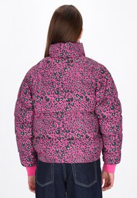 Jachetă căptușită cu un model de leopard roz, accentuat cu detalii verzi. Guler înalt și manșete elastice. Materialul pare lucios, cu o textură fină.