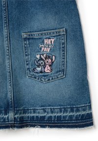Denimrock mit einer Gesäßtasche, die mit blauen und pinken gestickten Zeichen verziert ist, mit dem Text "HEY du bist MEIN FAVORIT," und einem fransigen Saum.